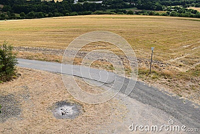 fireplace in dry grass next to a dirt road Stock Photo