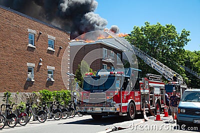 Firetruck and a fire in a a residential building in Montreal Editorial Stock Photo