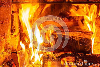 Firewood burning in fire burns in the fireplace. The brick oven gives heat and heat from the burnt logs. Burning coals and flames Stock Photo