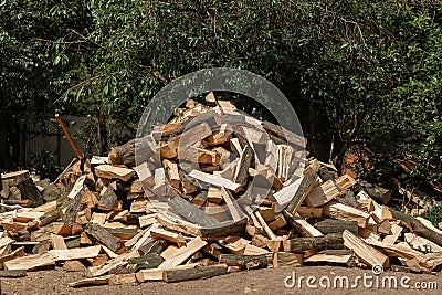 Firewood chopped with an ax for the stove lies in a heap in the yard. Chopped glades Stock Photo