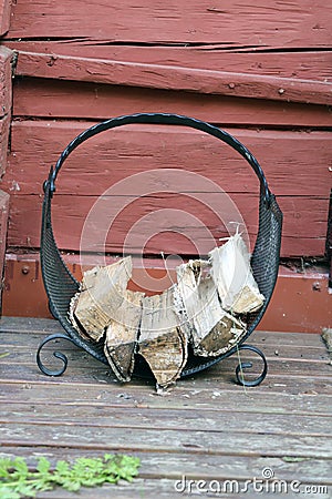 Black Metal Firewood Holder Loaded with Firewood for Sauna in Finland Stock Photo