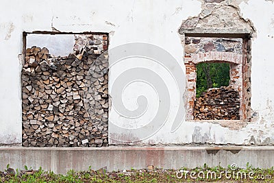 Firewood piles in window hole Stock Photo