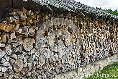 Firewood stacked in a woodpile under a canopy Stock Photo