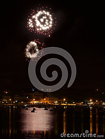 Fireworks in Birzebugga, Malta. Colorful firewotks on night time with reflections in the water. Birzebugga, Malta Stock Photo