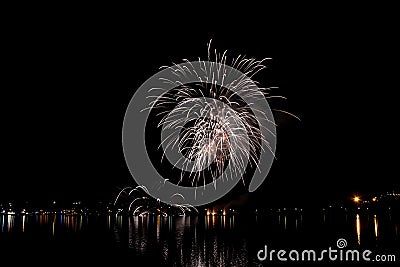 The fireworks paint the sky in various colors and are reflected in the Miseno lake, creating a breathtaking panorama. Stock Photo