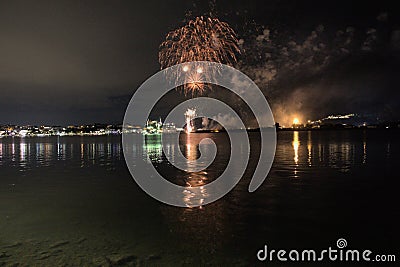 The fireworks paint the sky in various colors and are reflected in the Miseno lake, creating a breathtaking view. Stock Photo