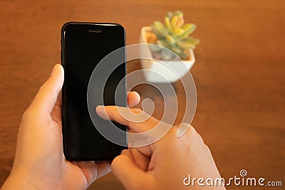 The firm grip of a male hand on a sleek mobile phone reveals a modern shopping experience. With deft fingers, he navigates through Stock Photo