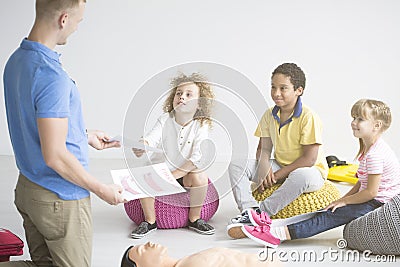 First aid instructor teaching children Stock Photo