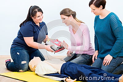 First aid trainees learning to use defibrillator for reanimation Stock Photo