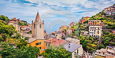 First city of the Cique Terre sequence of hill cities - Riomaggiore with tower of Church of San Giovanni Battista. Superb summer s Stock Photo