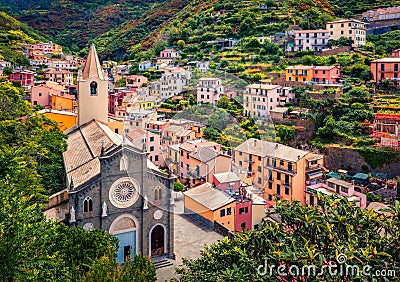 First city of the Cique Terre sequence of hill cities - Riomaggiore with tower of Church of San Giovanni Battista. Wonderful summe Stock Photo