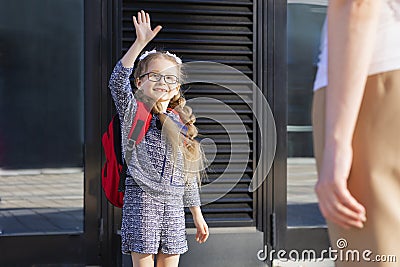 Back to school kids. mother lead little schoolgirl in uniform, schoolbag in the first grade. Stock Photo