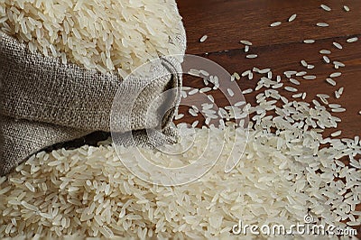 Rice grains are poured into a linen bag. Stock Photo