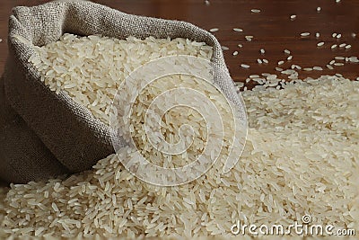 Rice grains are poured into a linen bag. Stock Photo