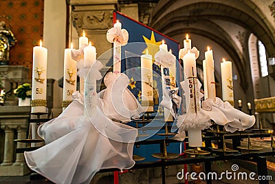 First holy communion or confirmation burning candles rowed up in church before ceremony beautiful decoration Editorial Stock Photo