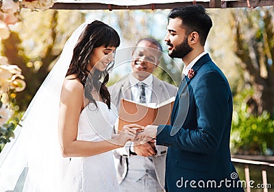 First I gave you my heart, now I give you this ring. an affectionate young bride slipping a ring on to her grooms finger Stock Photo