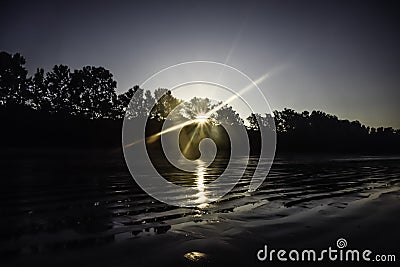 The first light of the day - The light from the sun shines through the trees in the morning at the beach Stock Photo