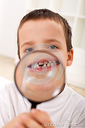 The first lost tooth - boy with magnifier Stock Photo