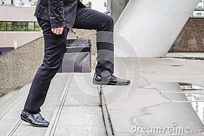 First morning of close up view of foot Businessman walking up the stairs in a rush hour to work. Hurry time. Stock Photo
