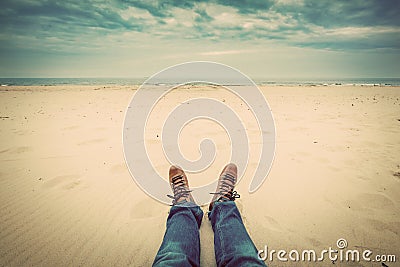 First person perspective of man legs in jeans on the autumn beach Stock Photo
