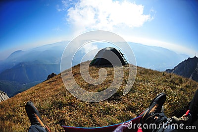 First person shot of tent on alpine cliff edge Stock Photo