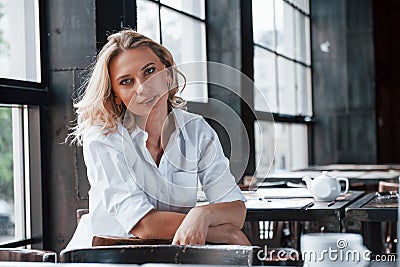 First person view. Psychologist listens to the patient. Businesswoman with curly blonde hair indoors in cafe at daytime Stock Photo