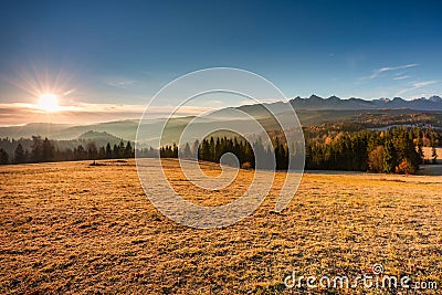 The first rays of the rising sun over the autumnal Tatra Mountains. The pass over Lapszanka. Poland Stock Photo