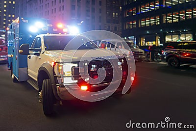 First responder ambulance on urban city street with lights flashing at night Stock Photo