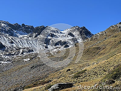 First snow on the rocky mountain peak Chilbiritzenspitz (2852 m) in the Albula Alps and above the alpine valley Stock Photo