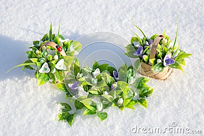 The first spring flowers are snowdrops form of handmade soap in mini baskets in the snow Stock Photo