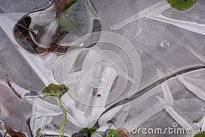 First is thin transparent ice and green grass under it Stock Photo