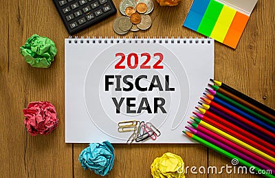 2022 fiscal new year symbol. White note, words 2022 fiscal year on beautiful wooden table, colored paper, colored pencils, paper Stock Photo