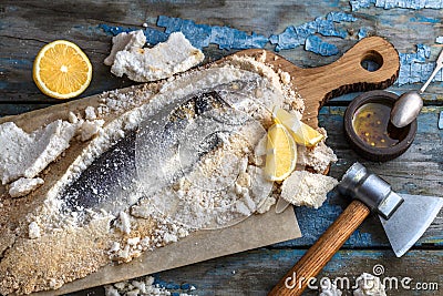 Fish baked in salt with lemon and oil, top view Stock Photo