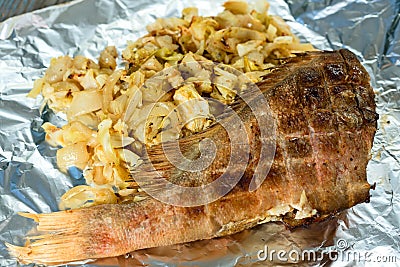 Fish baked with vegetables lies in a foil Stock Photo