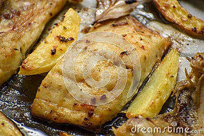 Fish dish cooked on oiled paper in the oven and potatoes on the side Stock Photo