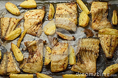 Fish dish cooked on oiled paper in the oven and potatoes on the side Stock Photo