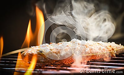 Fish on grill / Close up of seafood grilled fish food with salt on the grill fire and smoke Stock Photo