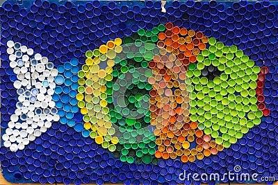 Fish mosaic deocoration made of cororful plastic bottle caps . S Stock Photo