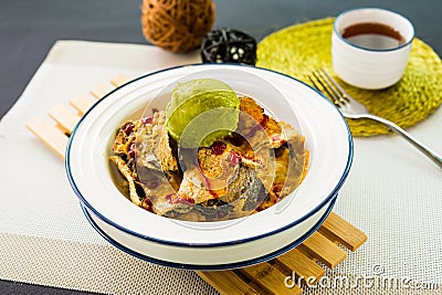 Fish Nachos topping with ice cream scoop served in bowl isolated on wooden bard side view of japanese seafood on table Stock Photo