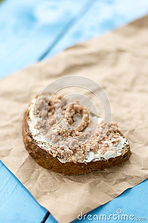 Fish pate spread on a slice of bread on the wrinkled brown paper Stock Photo