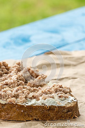 Fish pate spread on a slice of bread on the wrinkled brown paper Stock Photo