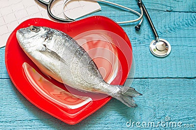 Fish on red heart plate and stethoscope Stock Photo