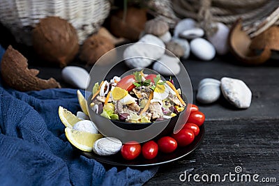Fish salad with sardines, harringe, tuna, tomato, lemon, lettuce, cabbage, olives, beans, corn, carrotes and eggs Stock Photo