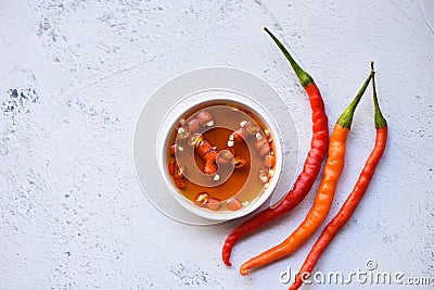 Fish sauce on white bowl and fresh chili on table, fish sauce obtained from fermentation fish or small aquatic animal, fermented Stock Photo
