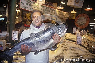 Fish seller at Salmon stand at Pike Place Public Farmers Market, Seattle, WA Editorial Stock Photo