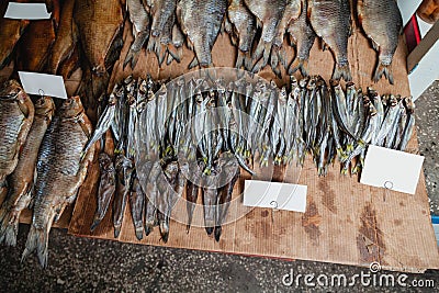 Rows of dried fish lie on counter Stock Photo