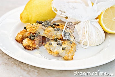 Fish Served With Lemons Tied in Cheesecloth Stock Photo