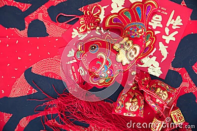 Fish-shaped ornaments and red envelopes on red spring couplets background.The Chinese characters on the spring couplets mean `happ Stock Photo