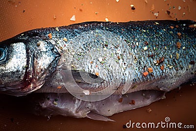 Fish and spices on a plastic cutting board. Fish in the process Stock Photo