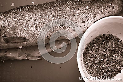 Fish and spices on a plastic cutting board. Fish in the process Stock Photo